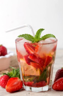 Çilek mojito. Parlak bir masada bir bardak çilek, nane, limon ve buz ile Soğuk yaz mojito kokteyl. yaz serinletici içecek.