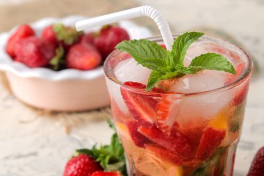 Çilek mojito. Doğal ahşap bir masa üzerinde bir bardak çilek, nane, limon ve buz ile soğuk yaz mojito kokteyl. Serinletici bir yaz içkisi. Close