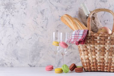 Hafif bir arka planda şarap meyvesi ve diğer ürünlerle piknik sepeti. Yaz dinlenme. Kamp. Doğada piknik.