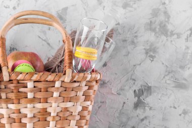 Hafif bir arka planda şarap meyvesi ve diğer ürünlerle piknik sepeti. Yaz dinlenme. Kamp. Doğada piknik.