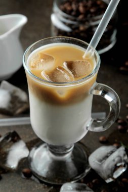 Koyu bir arka plan karşı cam bir beher süt ve buz küpleri ile Buz latte veya Buzlu kahve. ferahlatıcı bir içecek. yaz içkisi.