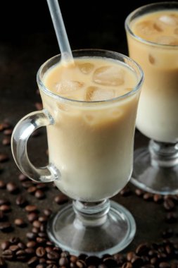 Koyu bir arka plan karşı cam bir beher süt ve buz küpleri ile Buz latte veya Buzlu kahve. ferahlatıcı bir içecek. yaz içkisi.