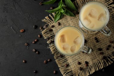 Koyu bir arka plan karşı cam bir beher süt ve buz küpleri ile Buz latte veya Buzlu kahve. ferahlatıcı bir içecek. yaz içkisi. üst görünüm