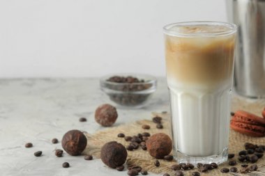 Buzlu latte veya buzlu kahve süt ve buz küpleri ile hafif bir arka plan üzerinde cam bir beher. ferahlatıcı bir içecek. yaz içkisi.