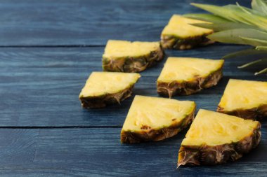 Taze olgun ananas yarım ve mavi ahşap arka plan üzerinde ananas dilimleri. Yaz. Meyve.