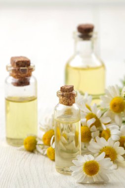 Papatya. Beyaz ahşap bir masa üzerinde aroma yağları ile papatya Tıbbi küçük çiçekler. Close