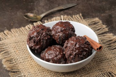 Sıvı çikolata tarçın çubuğu ve karanlık bir arka plan üzerinde kahve çekirdekleri ile Çikolatalı dondurma.