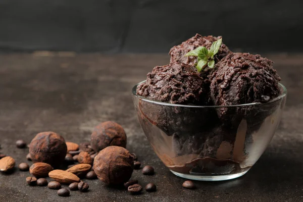 Chocolate ice cream with liquid chocolate with almonds and coffee beans on a dark background.