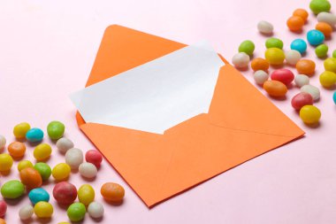 Parlak trendy pembe arka plan üzerinde metin ve renkli kaydırma için boş turuncu zarf.