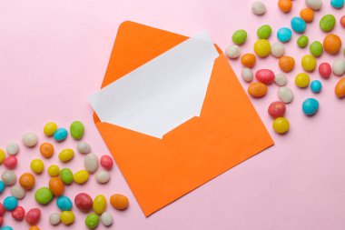 Turuncu zarf metin için boş ve parlak trendy pembe arka plan üzerinde renkli panting. üst görünüm.