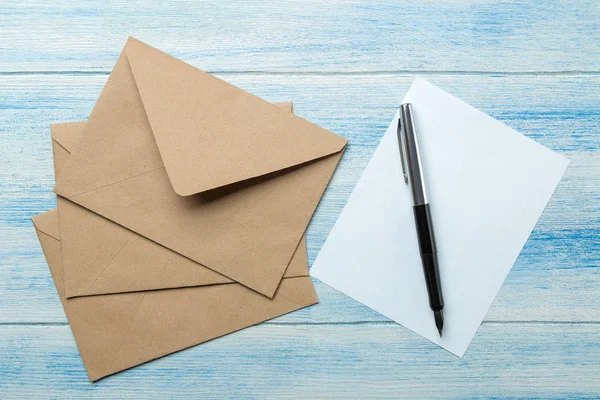 craft envelopes with blank for text on a blue wooden table. top view