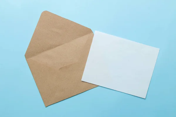 Craft envelope and blank for text on a bright trendy light blue background. top view