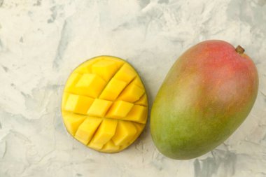 Olgun taze mango meyve ve adet ve hafif bir arka plan üzerinde yaprakları. tropikal meyve. üst görünüm. metin için alan