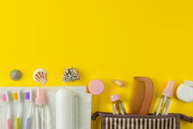 Parlak sarı bir arka plan üzerinde bir kozmetik çantası seyahat için kozmetik ve kişisel bakım ürünleri bir dizi. üst görünüm. seyahat kozmetik