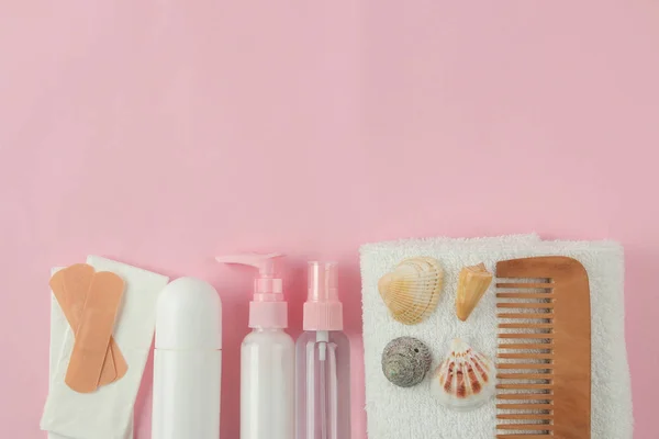 A set of cosmetics and personal care products for travel  on a light pink background. top view. travel cosmetics