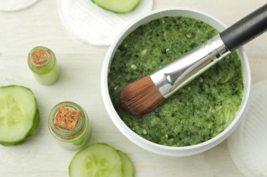 Salatalıklı yüz maskesi. Beyaz ahşap bir masa üzerinde salatalık özü ile Kozmetik. Spa. Güzellik. üst görünüm