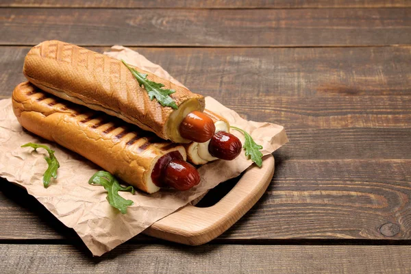 Fransız sosislileri. Kahverengi ahşap bir masa üzerinde tahtaüzerinde lezzetli sosisli sandviç. fast food sokak gıda. bir topuzun içinde sosis.