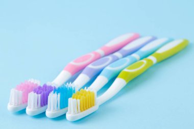 Ağız hijyeni. Yumuşak mavi arka plan üzerinde çok renkli diş fırçası. metin için alan