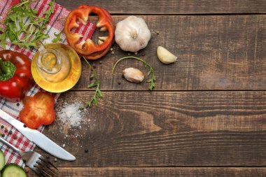 Yemek salatası için malzemeler. Çeşitli sebze ve baharatlar havuç, domates, salatalık, biber ve arugula kahverengi bir ahşap masada. üst görünüm.