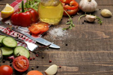 Yemek salatası için malzemeler. Çeşitli sebze ve baharatlar havuç, domates, salatalık, biber ve arugula kahverengi bir ahşap masada. üst görünüm.