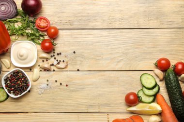 Yemek salatası için malzemeler. Çeşitli sebze ve baharatlar havuç, domates, soğan, salatalık, biber ve doğal ahşap bir masa üzerinde arugula. üst görünüm.