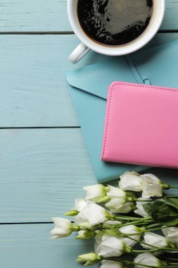 Birkaç dizüstü bir fincan kahve ve açık mavi ahşap bir masa üzerinde beyaz çiçekler. üst görünüm. ofis araçları