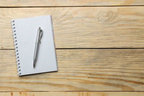 open notebook and pen on the natural wooden table. top view. office tools