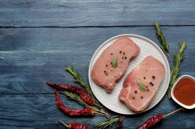 Bir tabak, et ve pişirme için malzemeler, baharat otlar ve hafif bir arka plan üzerinde sebze çiğ domuz biftek. üst görünüm