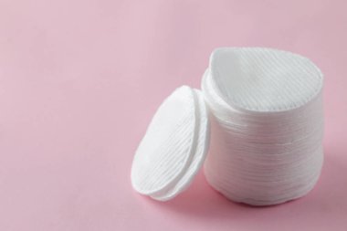 Kozmetik pamuk pedleri. Hassas pembe arka planda pamuk pedleri yığını. Spa. Close.