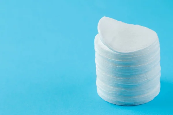 Cosmetic cotton pads. a stack of cotton pads on a gentle light blue background. spa. close-up.