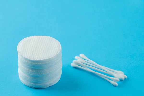 Cosmetic cotton pads. a stack of cotton pads and cotton swabs on a gentle light blue background. spa. close-up.