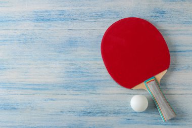 İki ping pong raket. Masa tenisi raketleri ve mavi ahşap masada bir top. spor oyunu. üst görünüm
