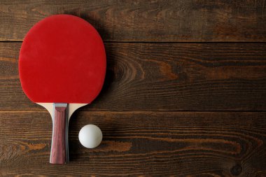 İki ping pong raket. Masa tenisi raketleri ve kahverengi ahşap masaüzerinde bir top. spor oyunu. üst görünüm