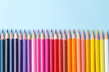 Parlak mavi bir arka plan üzerinde renkli kalemler ile kompozisyon. üstten görünüm. text.frame mekanı