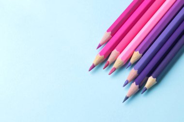 parlak mavi zemin üzerine kalem ile çok renkli kalemler ile kompozisyon. yakın çekim. metin için yer.