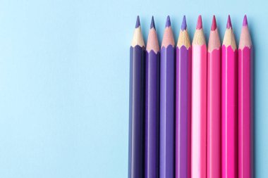 parlak mavi zemin üzerine kalem ile çok renkli kalemler ile kompozisyon. yakın çekim. metin için yer.