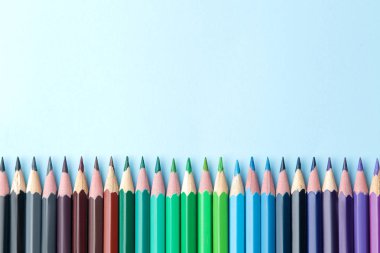 Parlak mavi bir arka plan üzerinde renkli kalemler ile kompozisyon. üstten görünüm. text.frame mekanı