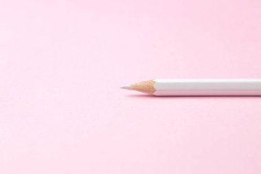 Nazik moda pembe arka plan üzerinde bir beyaz kalem. metin için yer.