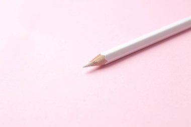 Nazik moda pembe arka plan üzerinde bir beyaz kalem. metin için yer.