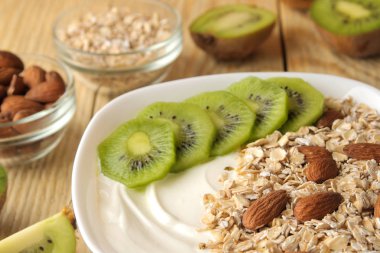 Doğal ahşap masada kivi badem ve yulaf ezmesi ile Yunan beyaz yoğurt. Kahvaltı. Close. sağlıklı gıda