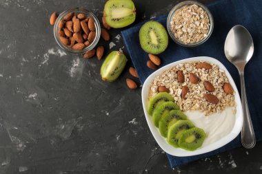 Koyu grafit masada kivi badem ve yulaf ezmesi ile Yunan beyaz yoğurt. Kahvaltı. üst görünüm. sağlıklı gıda