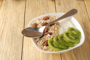 Doğal ahşap masada kivi badem ve yulaf ezmesi ile Yunan beyaz yoğurt. Kahvaltı. sağlıklı gıda