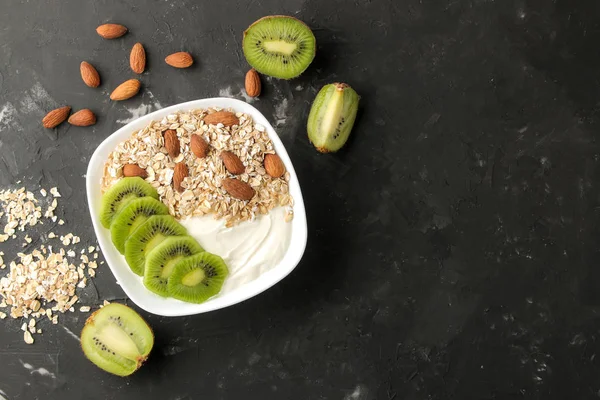 Koyu grafit masada kivi badem ve yulaf ezmesi ile Yunan beyaz yoğurt. Kahvaltı. üst görünüm. sağlıklı gıda