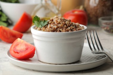 Karabuğday. Beyaz seramik kase maydanoz ve parlak bir masada domates ile lapa tahıllar. kahvaltı, sağlıklı gıda.