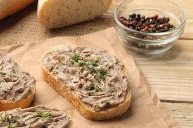 Doğal bir ahşap masada ekmek için otlar ile taze ev yapımı tavuk ciğeri pate. Sandviç. Close