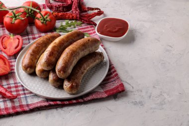 Hafif bir arka plan üzerinde kırmızı sos ve baharatlar ile bir tabakta lezzetli ızgara sosis. B-B-Q. 