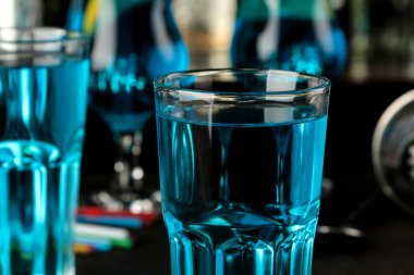 Bir barda kahverengi koyu bir masada limon ve nane ile bir kokteyl cam Kokteyl mavi lagün. bar aksesuarları.