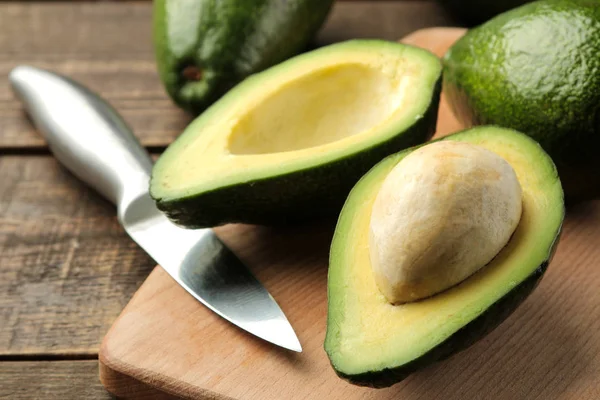 Aguacate Fresco Sabroso Una Tabla Cortar Sobre Fondo Madera Marrón —  Fotos de Stock