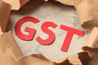 Gst kelimesi ve yırtık kağıt. Zanaat kağıt arka plan üzerinde Vergiler.