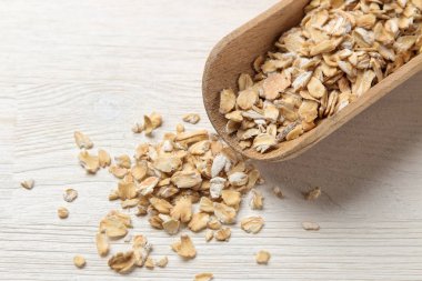 Beyaz bir tahta masa üzerinde tahta bir kaşık kuru yulaf ezmesi gevreği. sağlıklı beslenme. sağlıklı gıda.